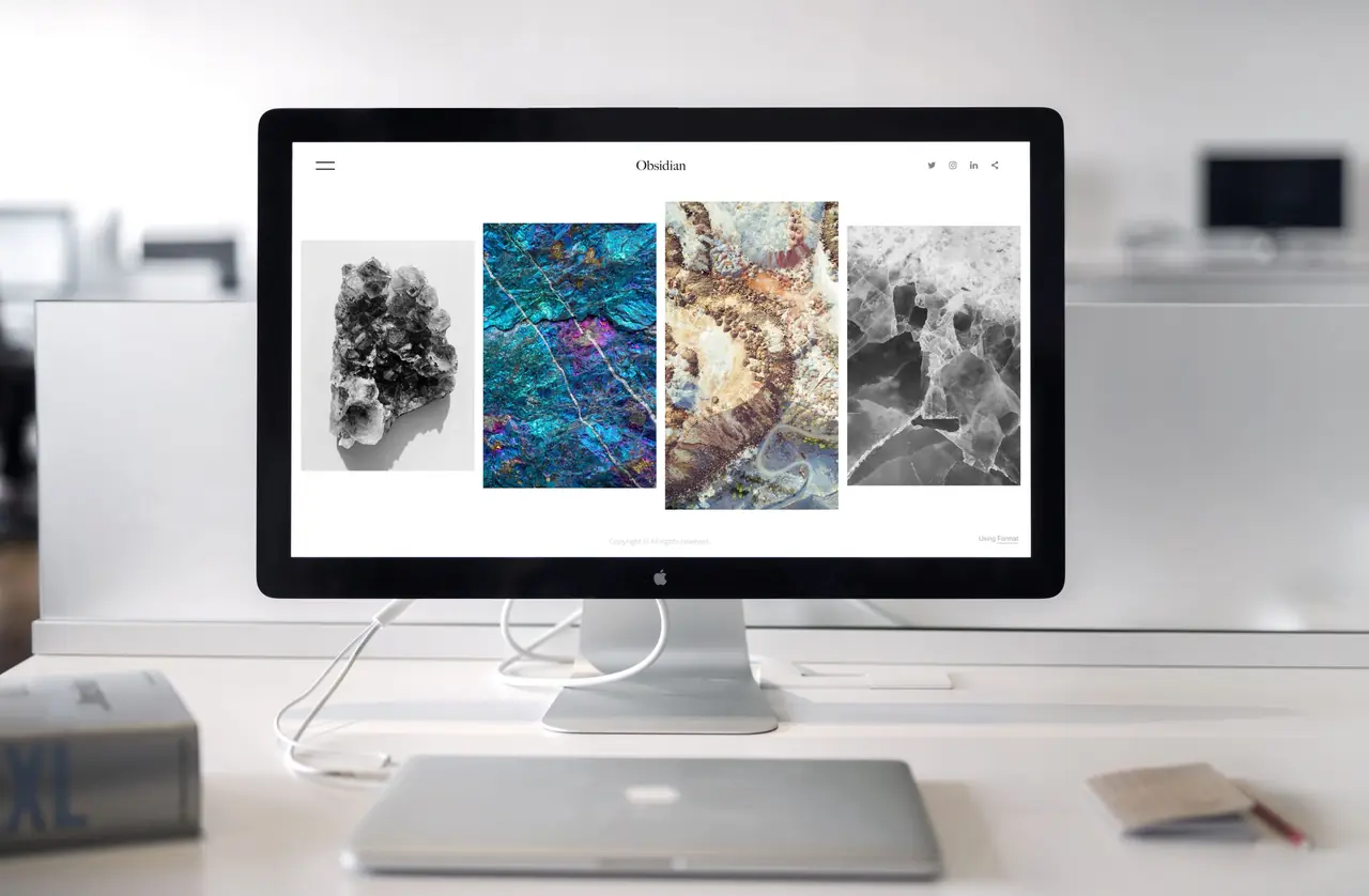 Contemporary studio desk with dual monitors displaying web design layouts