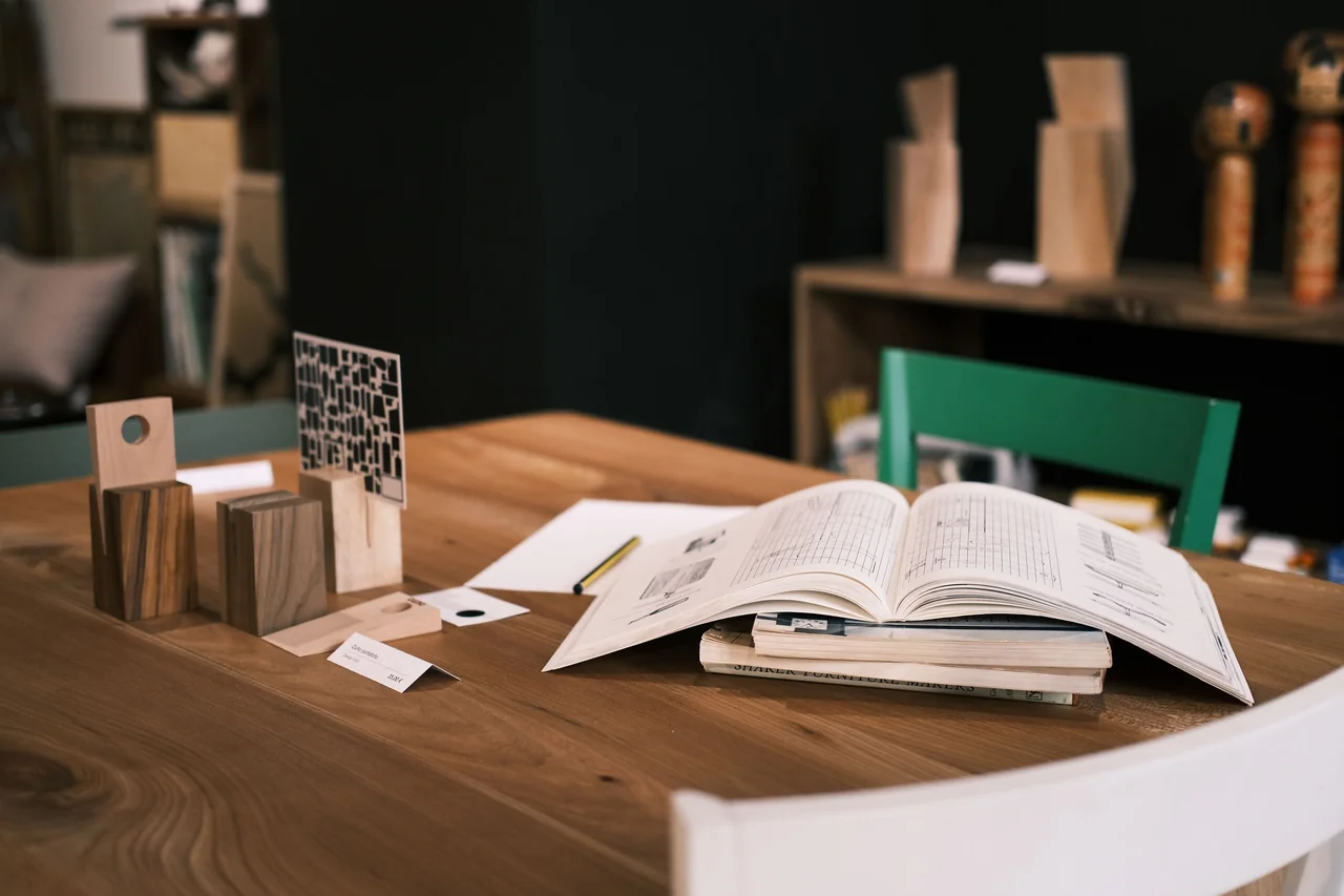 Minimalist desk interior with open publication, fine wooden accessories, and serene lighting