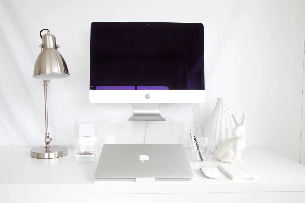 Minimalist design studio environment with clean white computer desk and structured layout