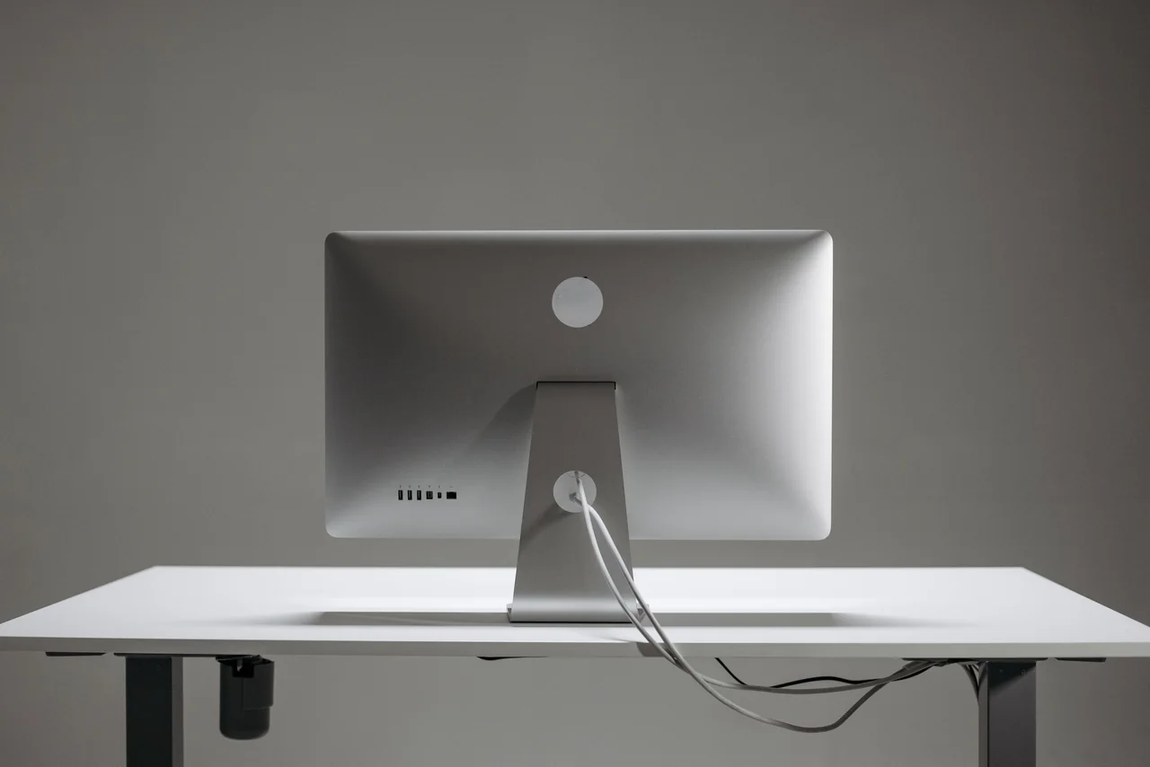 Minimalist desk setup with silver computer and editorial layout concept